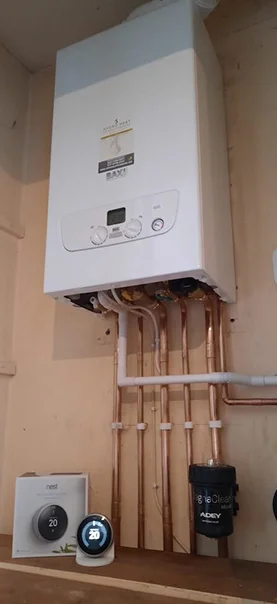White Ideal Logic combi boiler installed with copper pipes and Nest thermostat